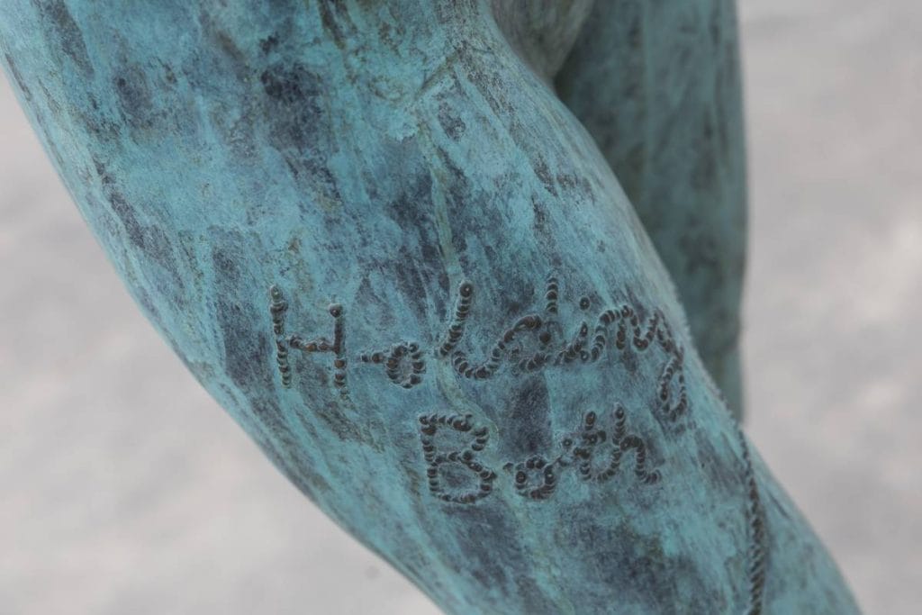 Photograph: Anna Kučera
Shwoing the thigh of the Sculpture ' holding both' which features a welded title on the bronze.